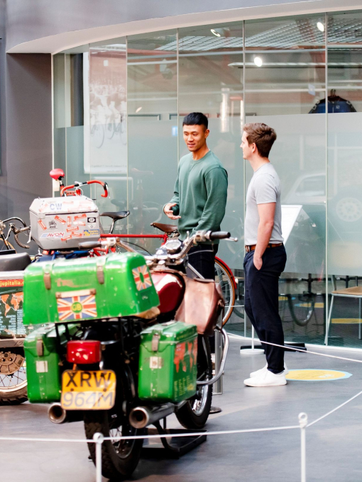 Two men looking at an exhibit of motorbikes at Coventry Transport Museum.