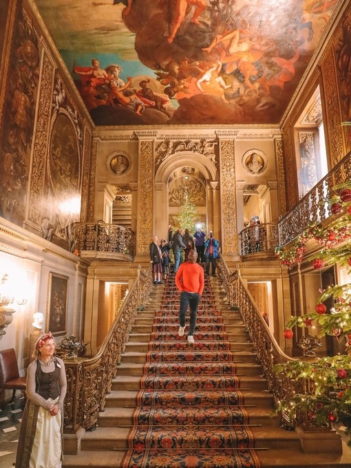 Groupe de personnes descendant des escaliers sous un plafond peint