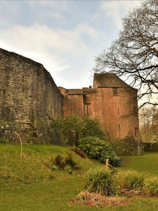 Exterior of a red-brick castle and fortified wall in winter.