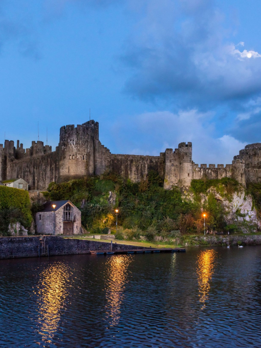 A long range shot of Pembroke Castle at night