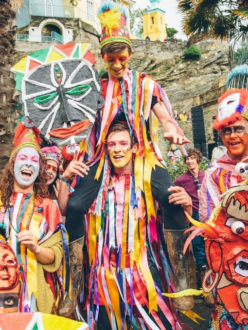 Group of performers in colourful costumes with faces painted