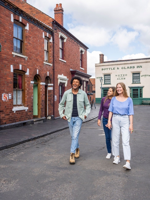 three friends explore the streets of a period living museum.