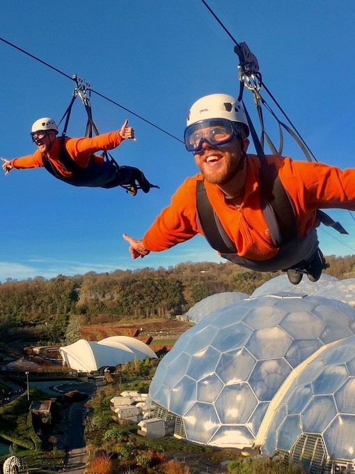 Due persone sospese su una zipline sopra l'Eden Project