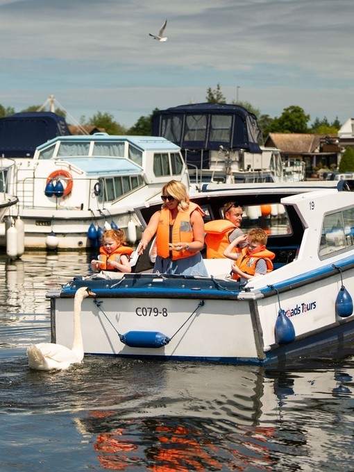 A family riding on a boat in the Norfolk Broads