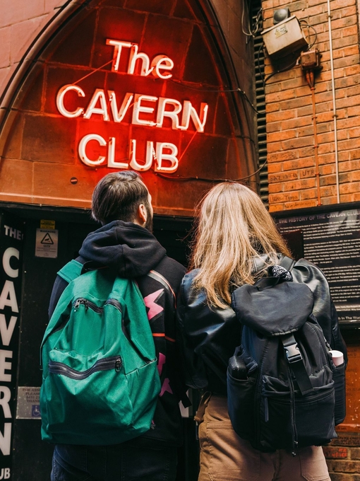Man and woman standing on the street outside a club with sign reading: The Cavern Club
