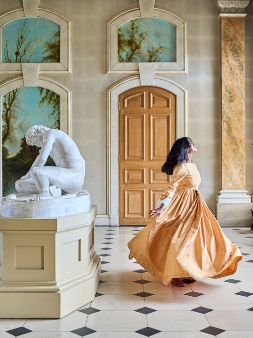 A woman dances in a gallery room at a heritage property