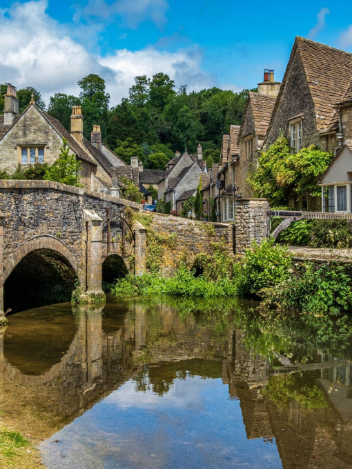 Blue skies and reflections in the picturesque Cotswold village of Castle Combe.