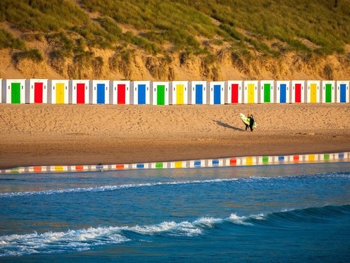 Idyllic Scene On Surfers Beach With Beautiful Beach Huts Reflecting In The Water