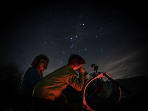 Child stargazing through telescope
