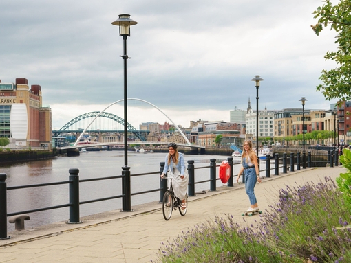 Two men skateboard along the River Tyne in Newcastle
