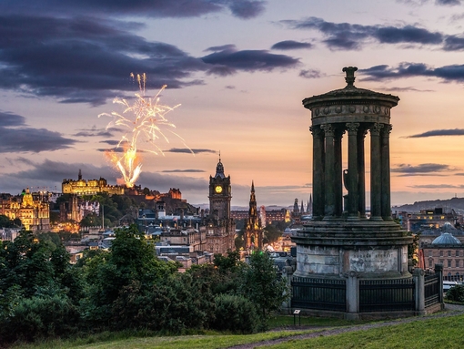 Fireworks at dusk in the sky over historic monument.
