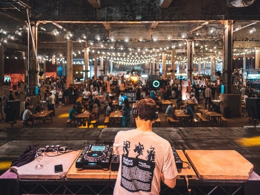 DJ playing to groups of people at Manchester Craft Beer Festival, in Depot Mayfield, Manchester