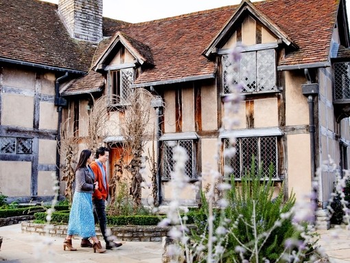 Couple walking around the exterior of Shakespeare's Birthplace, Stratford-upon-Avon, Warwickshire, England