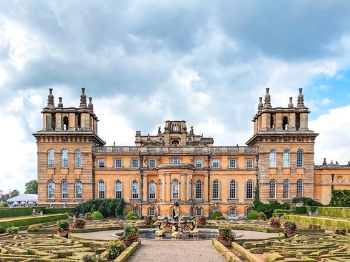 Woman walking in Blenheim Palace gardens surrounded by greenery