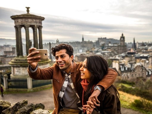 A young couple taking a selfie of view over historic town