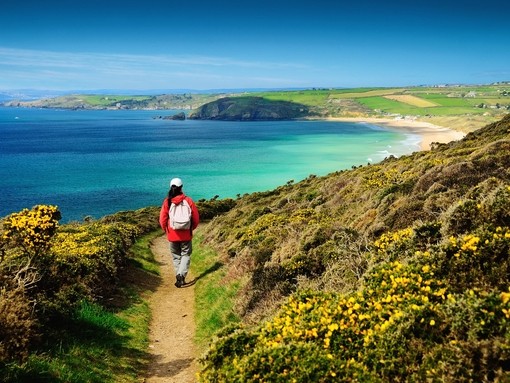 A person on a footpath on the coastal path near sea