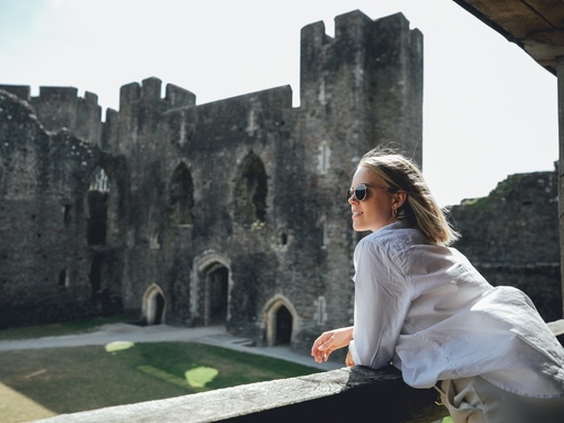 A woman in sunglasses looking out across Caerphilly Castle