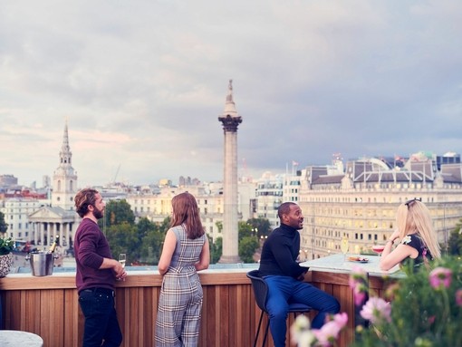 People having a drink at a rooftop bar under a grey sky