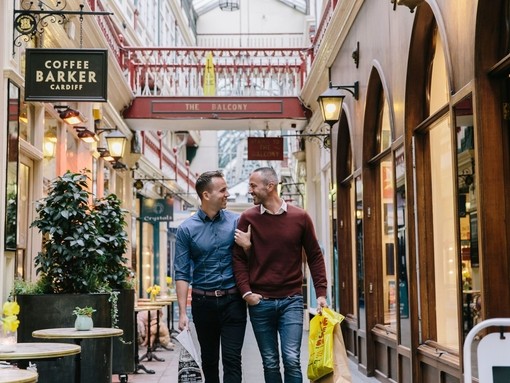 Una pareja gay disfruta de las instalaciones comerciales de Castle Arcade en Cardiff, Gales