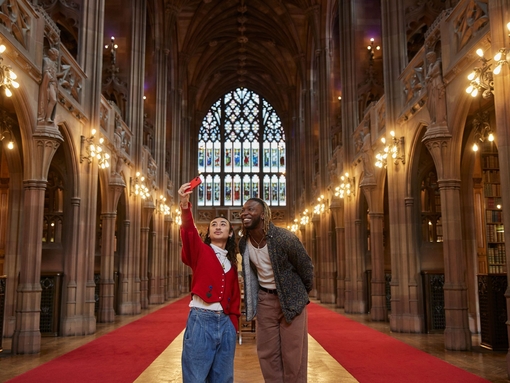 رجلان يلتقطان صورة سيلفي داخل مكتبة كبيرة.