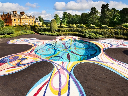 Ground pool sculpture in the landscape at Jupiter Artland with house and topiary gardens in distance