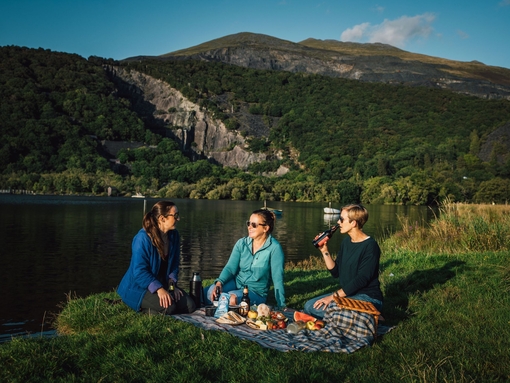 Friends having a picnic in grassland by a glacially formed lake.