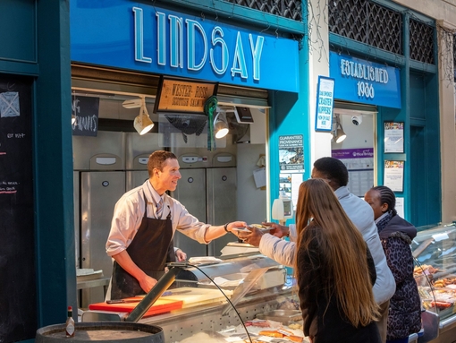 A fishmonger serving a customer at Grainger Market in Newcastle
