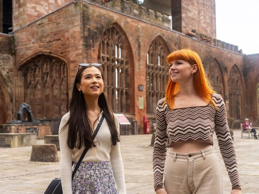 Two women explore the ruins within the grounds of a Cathedral