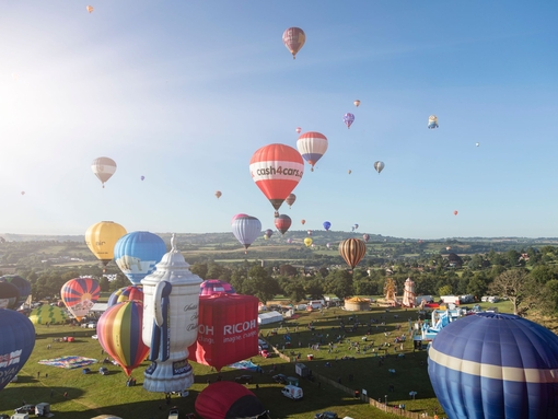 Colourful hot air balloons over floating above countryside
