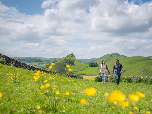 A man and a woman walk in open countryside