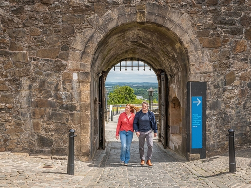 A couple exploring the grounds of a medieval castle.