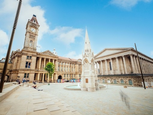 Historical building, with a clock tower, beside a fountain