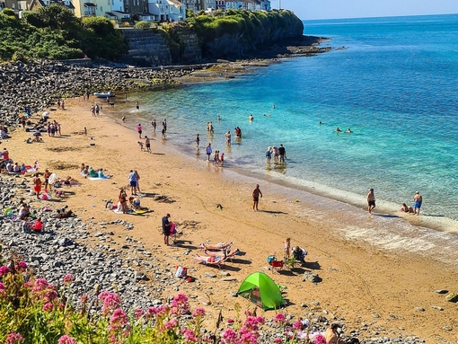 View of a bay with sandy beach and turquoise water with people