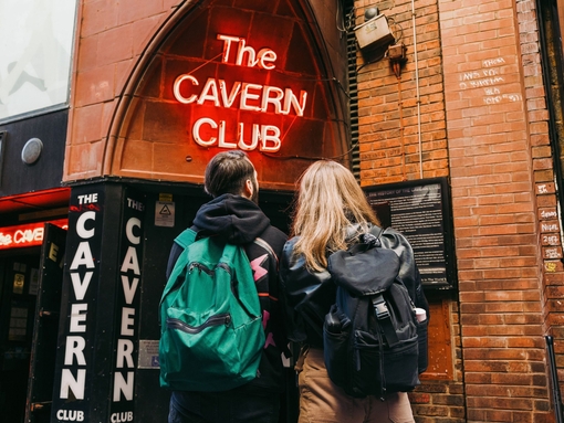 Man and woman standing on the street outside a club with sign reading: The Cavern Club