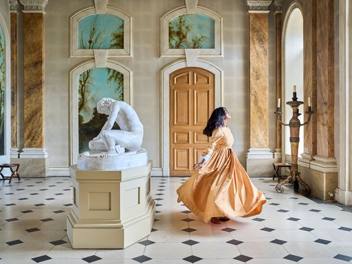 A woman dances in a gallery room at a heritage property