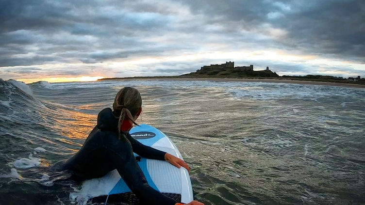 Rear view of a woman floating in the sea with paddleboard