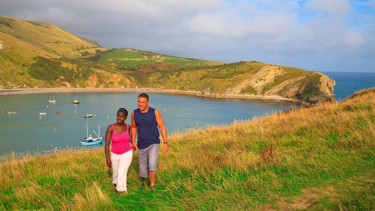 A couple walking on the clifftop.