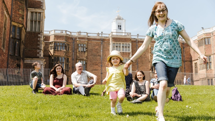 Children and parents sitting on the fields around Temple Newsam in Leeds