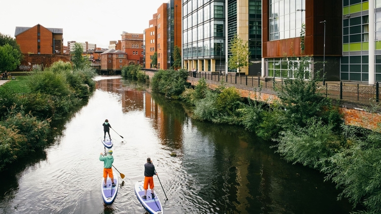 A group of people paddleboarding down the river Don in Sheffield