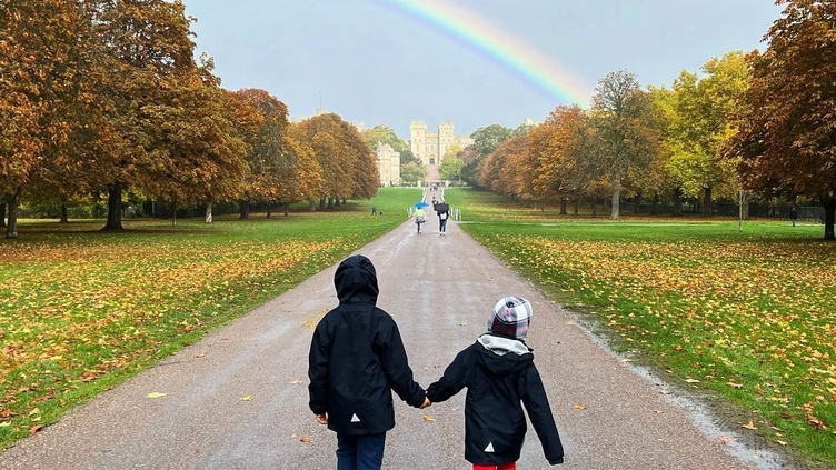 A couple walking towards Windsor Castle on the Long Walk in the Great Park