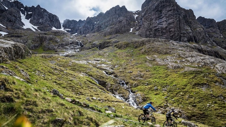 Two mountain bikers cycling downhill down a mountain