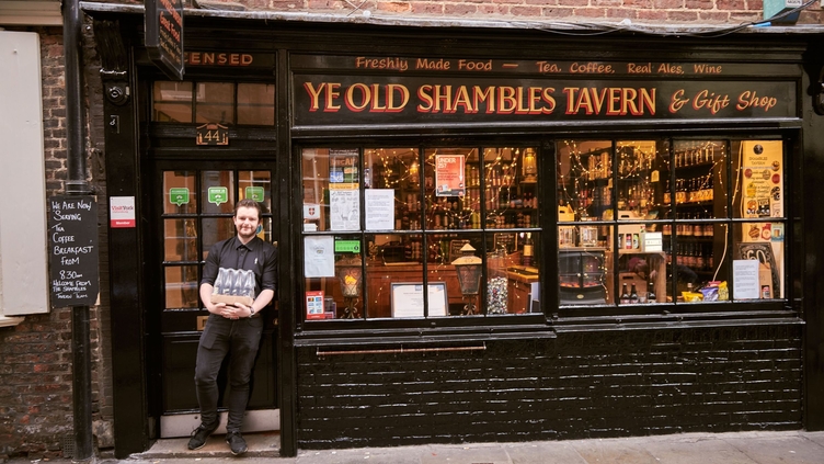 Man standing outside Ye Old Shambles Tavern