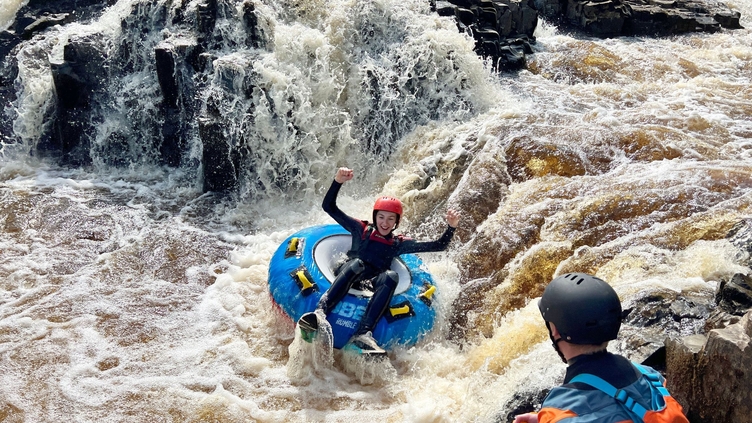 A woman rafting down some rapids at Endless Adventure North East in Newcastle