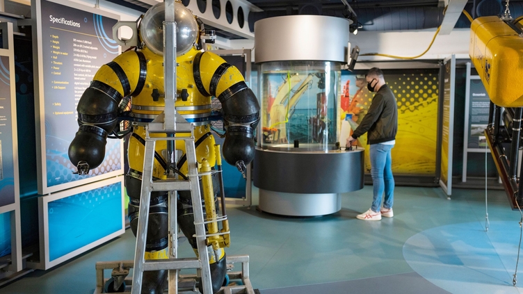 A man looking at an exhibit in a maritime museum. 