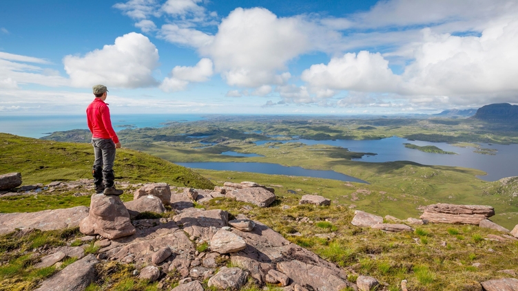 Man looking out over landscape from hilltop