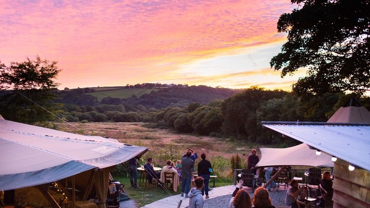 Groups of people watching the sunset at Fforest Farm