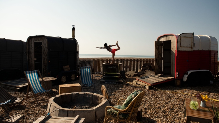 Woman holds a yoga pose at the Beach Box Sauna in Brighton