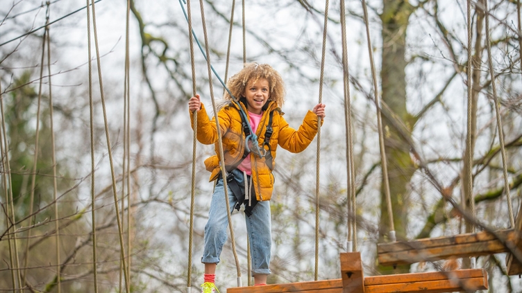 A girl on the TreeZone Aerial Adventure Course on the shores of Loch Lomond