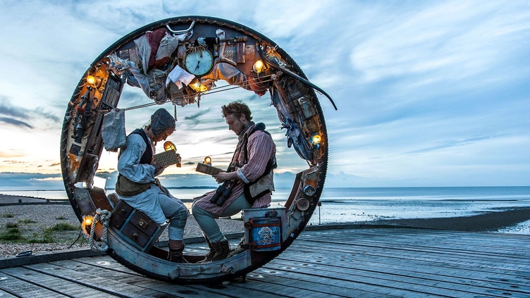 Two men sitting in a wheel during a performance