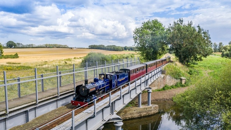 A steam train passing over a river in the Broads National Park